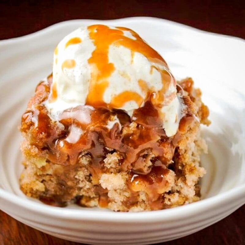 piece of apple cake with caramel sauce and ice cream in bowl