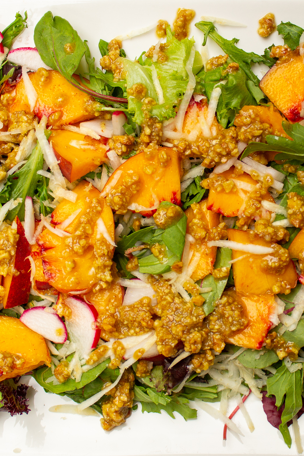 peach salad with walnut dressing on white plate p