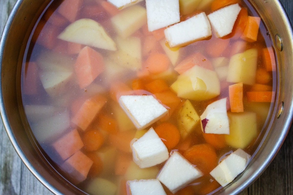 root vegetables in pot with water