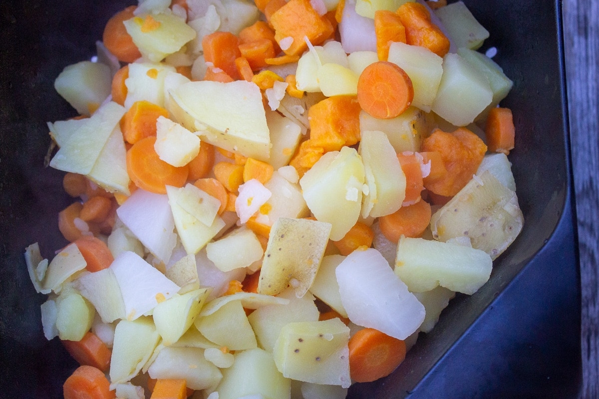 cooked root vegetables in colander draining