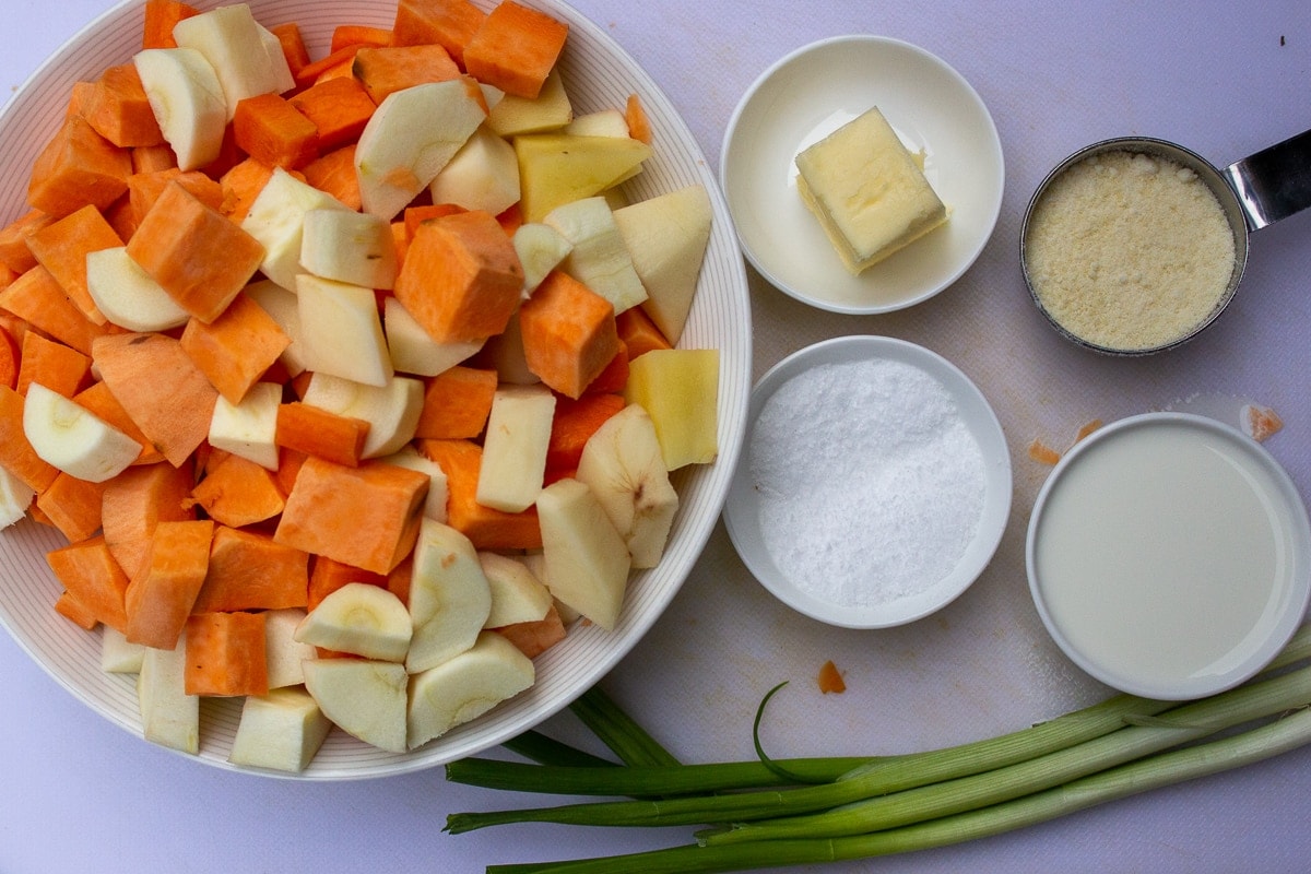 bowl of cut up root vegetables, butter, milk, salt, green onions