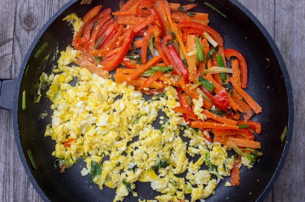 scrambled egg in pan with peppers and onion