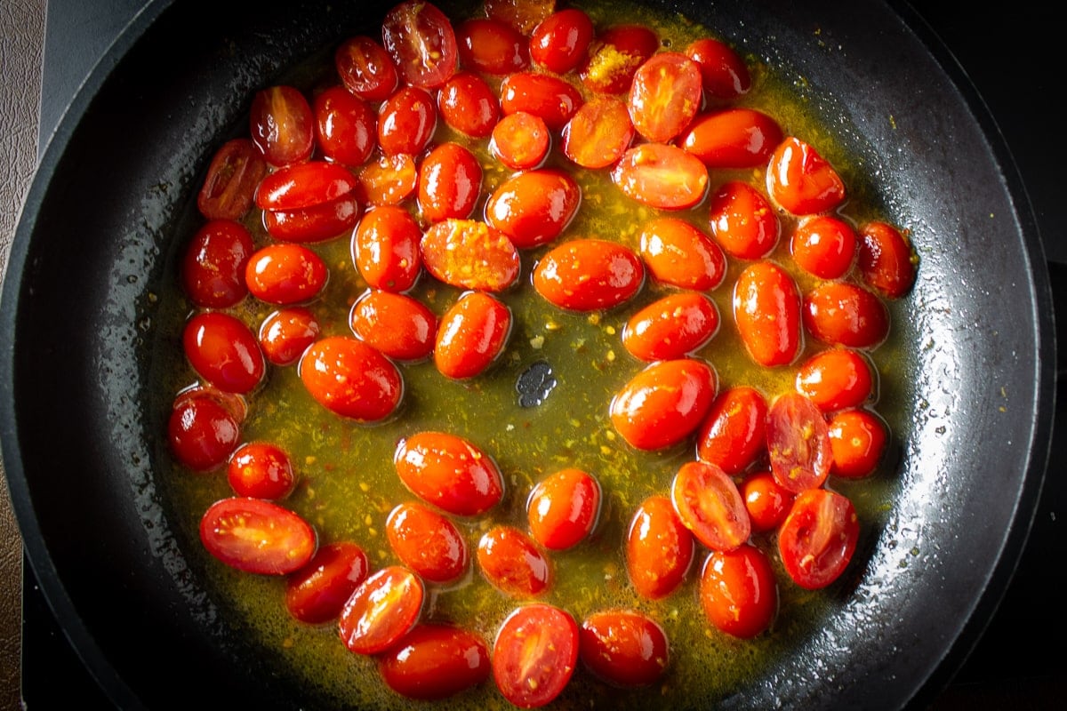 cherry tomatoes with citrus zest and juice in pan