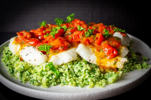 baked cod fillets covered with cherry tomato sauce over cauliflower spinach rice