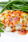 glazed stuffed salmon with ricotta on plate with beans.