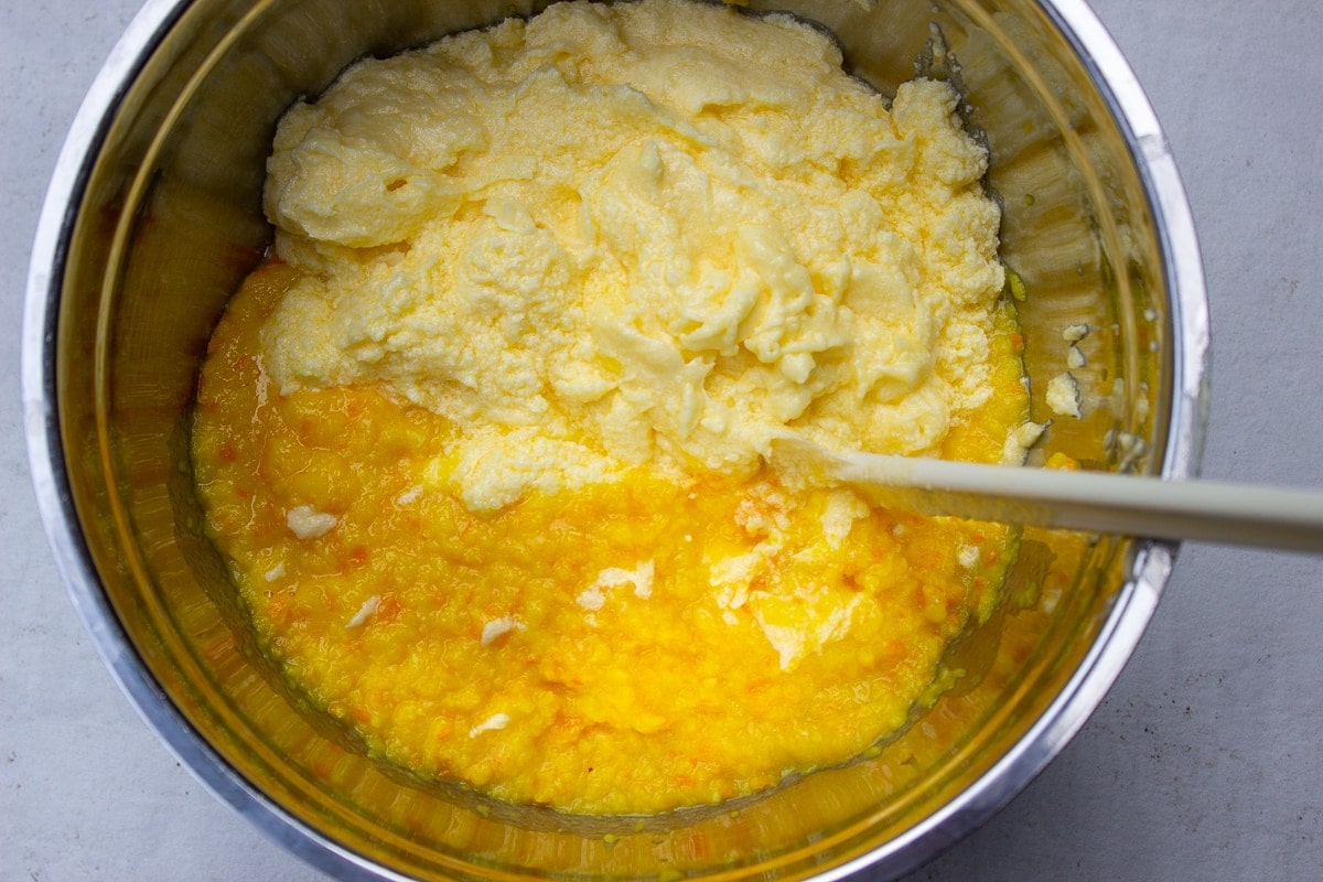 creamed butter, eggs and sugar with pulverized orange in a bowl