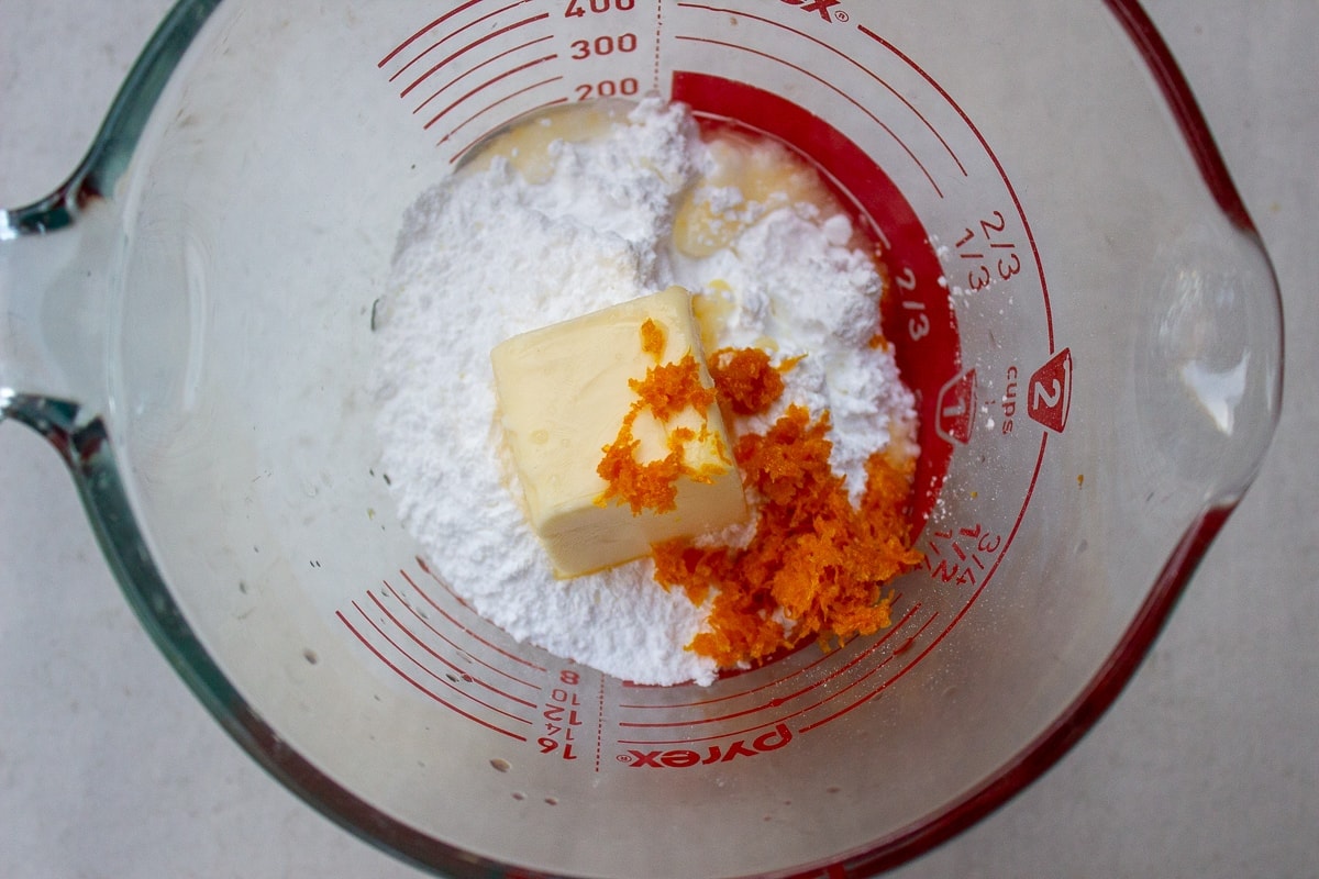 icing sugar, butter, zest and orange juice in measuring bowl.