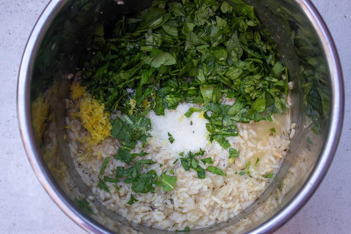 spinach, lemon and cheese on cooked risotto in instant pot
