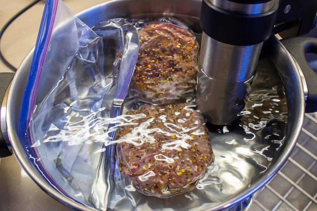 Burgers in ziploc bags in pot water bath sous vide.