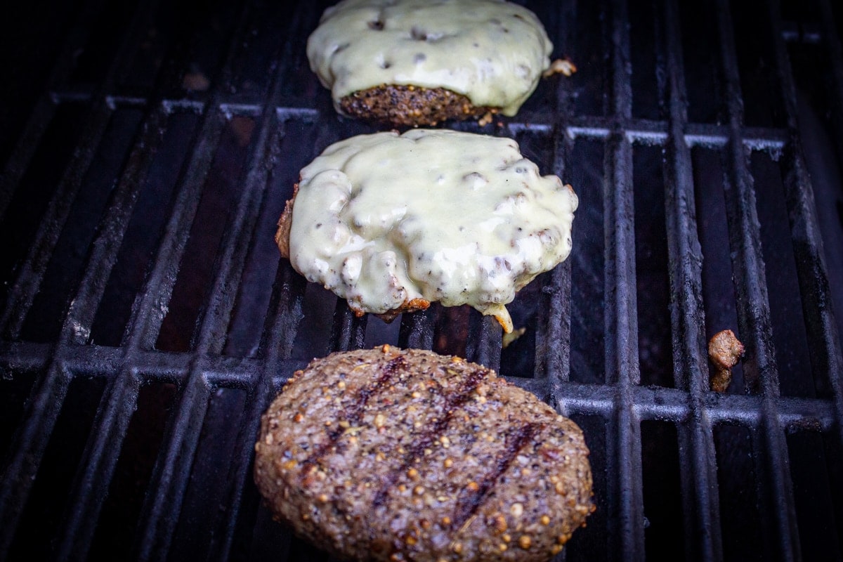 3 sous vide burgers grilling on grill
