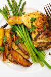 chicken quarter leg with asparagus and potatoes on plate p