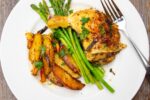 chicken quarter leg with asparagus and potatoes on plate