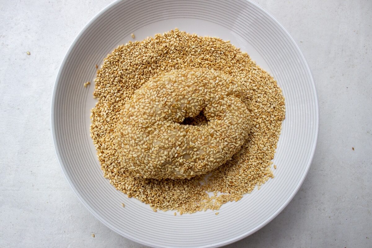 boiled bagels dipped in sesame seeds in bowl