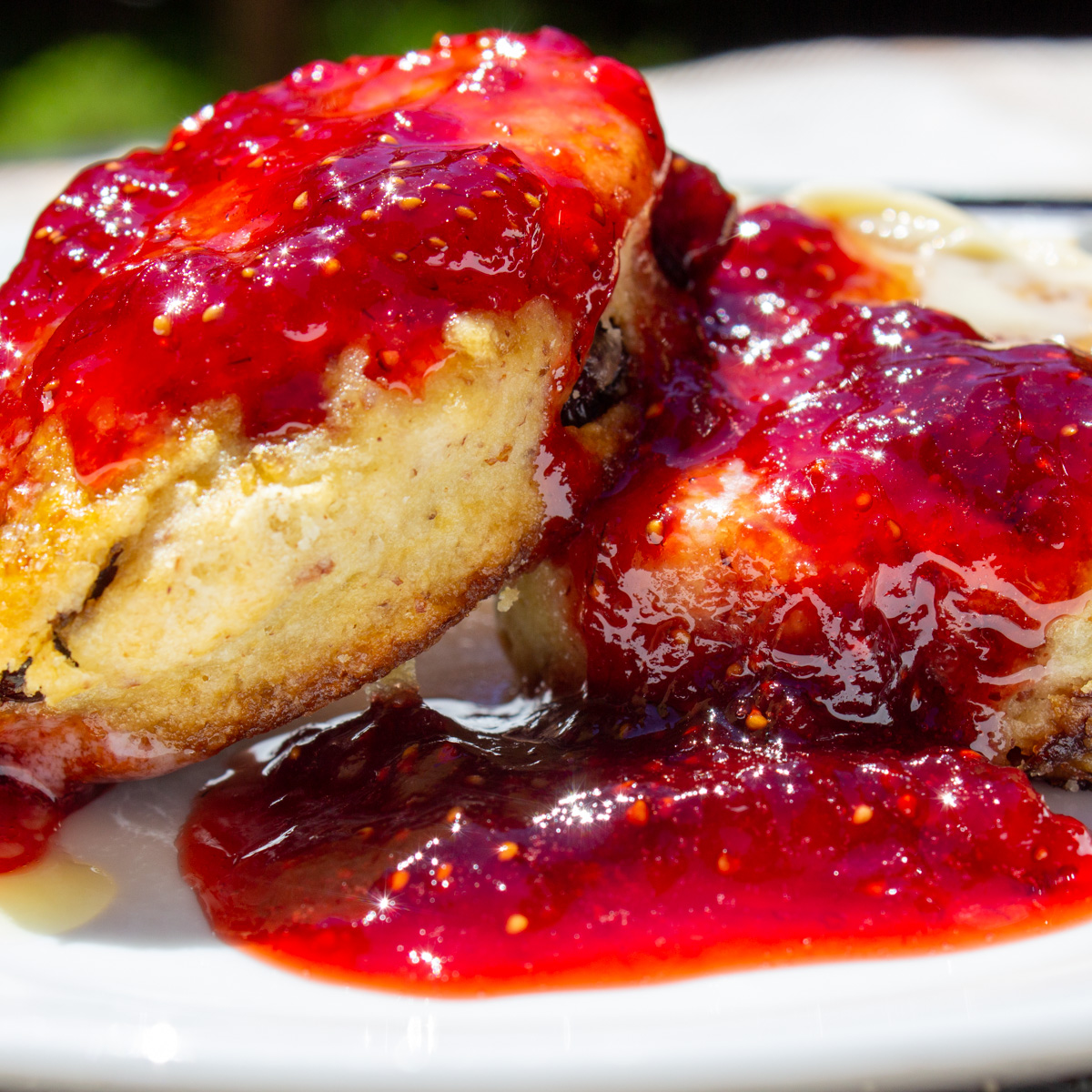 strawberry jam over scones on plate