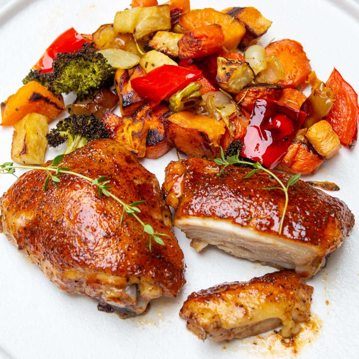 cooked chicken thighs on plate with vegetables