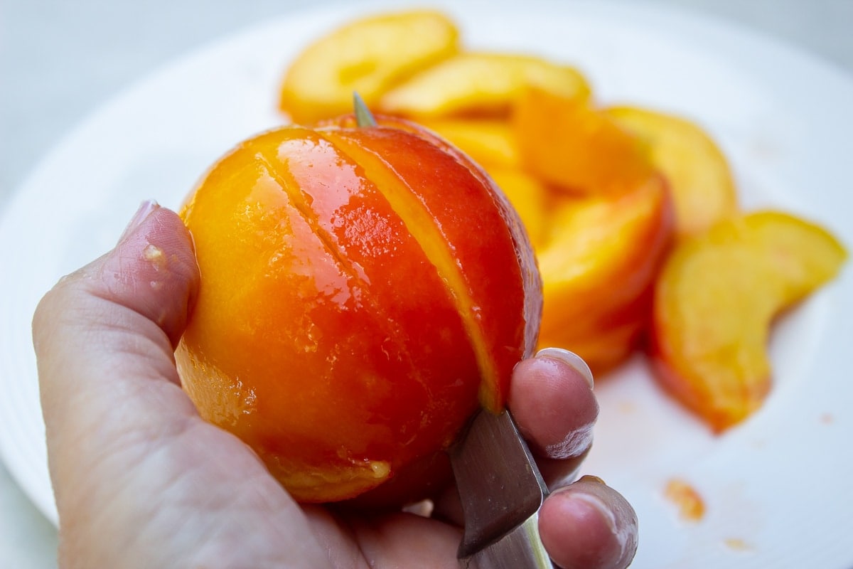 slicing a peach with small knife