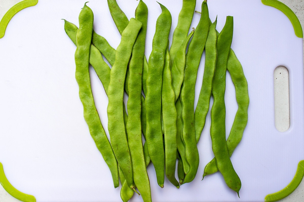 flat green beans raw on cutting board