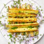 roasted zucchini spears on plate with microgreens