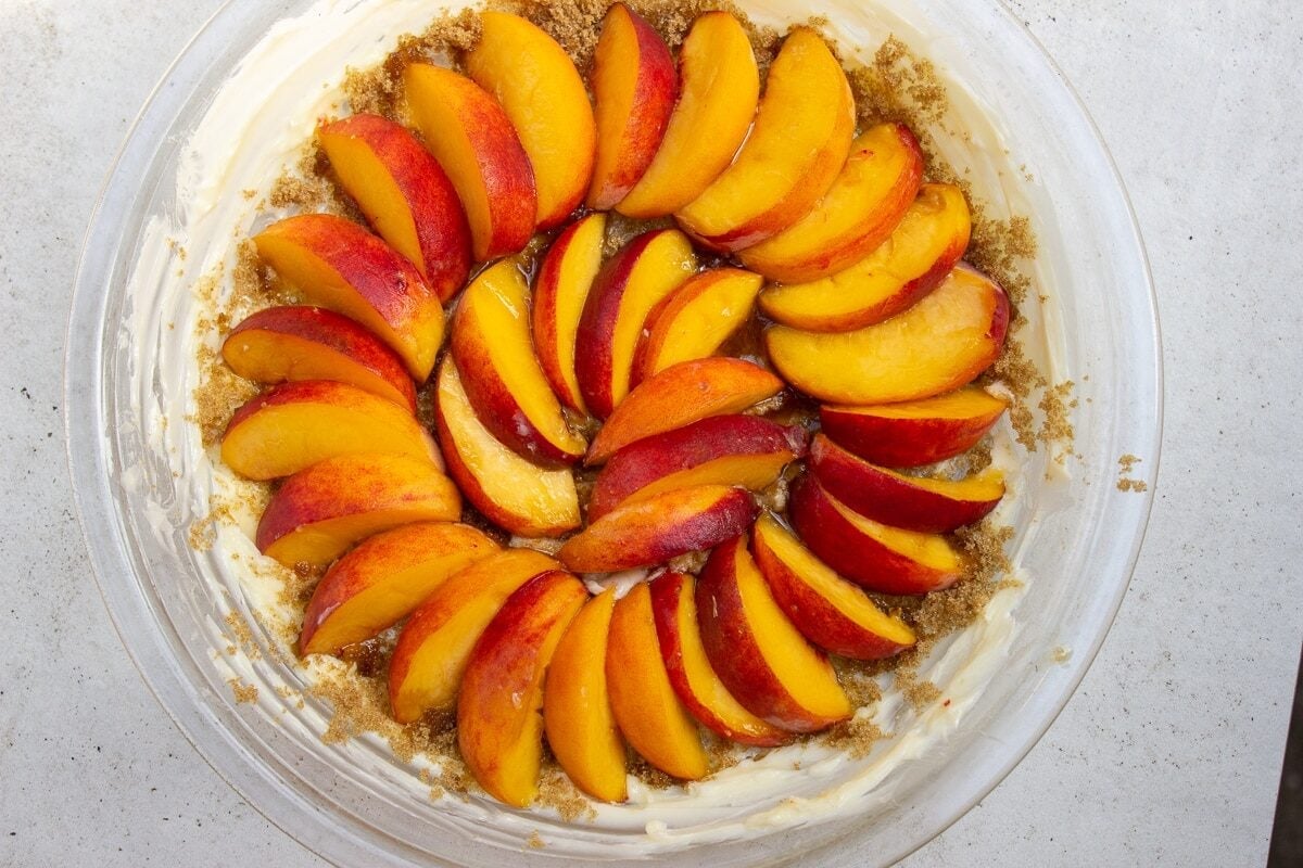 peaches fanned out over sugar in pie plate