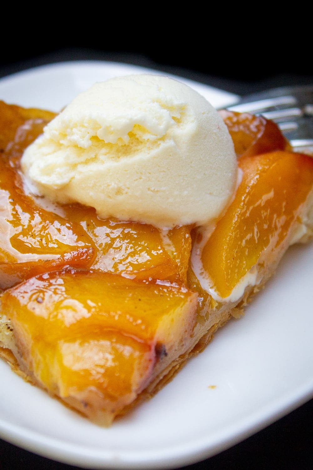 piece of peach tarte with ice cream on plate p1
