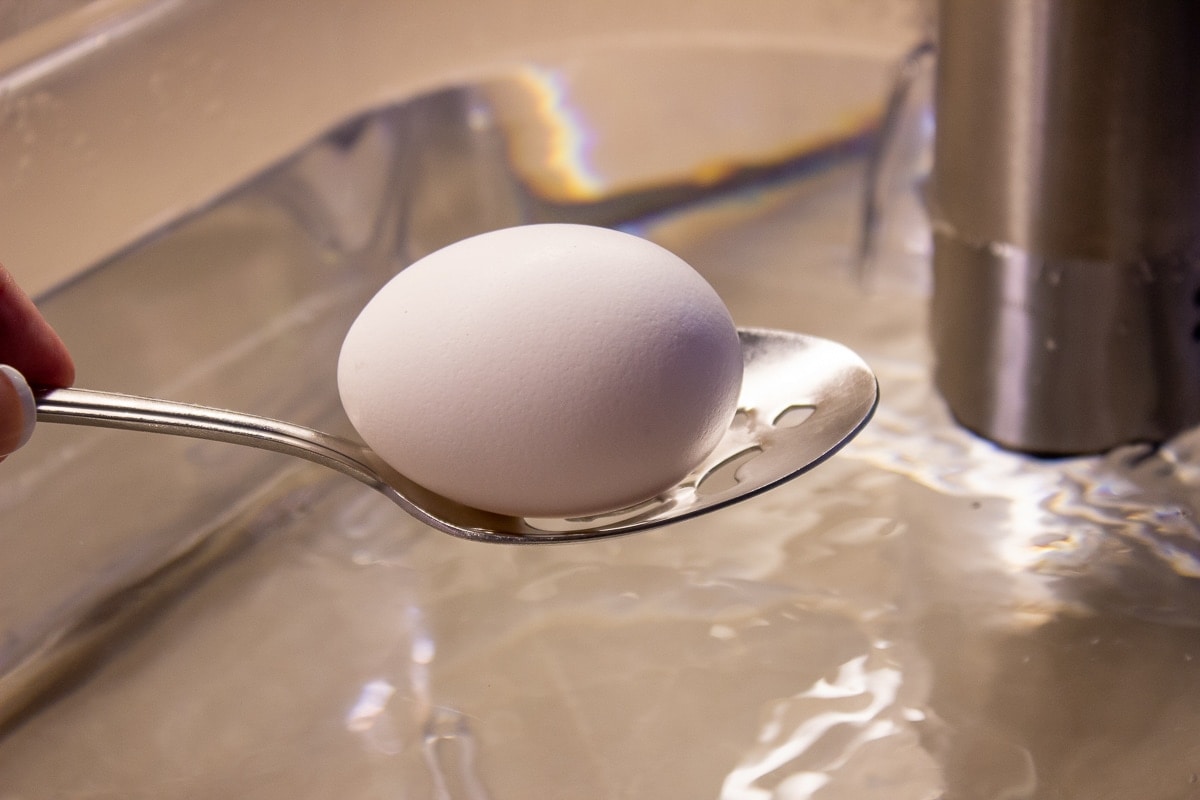 egg on spoon over water bath