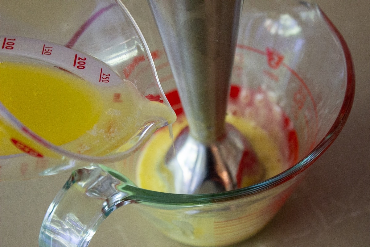 melted butter added to blended egg in bowl for hollandaise