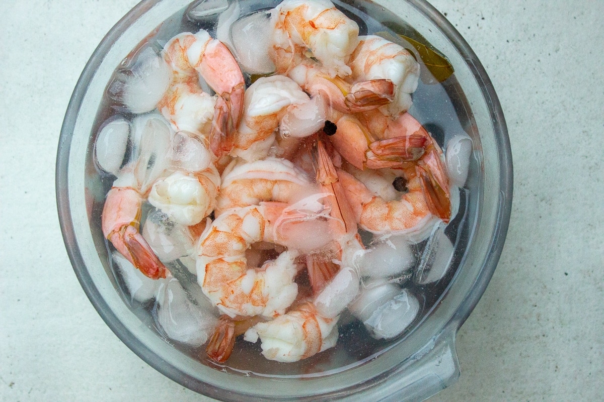 cooked shrimp cooling in a bowl of ice water