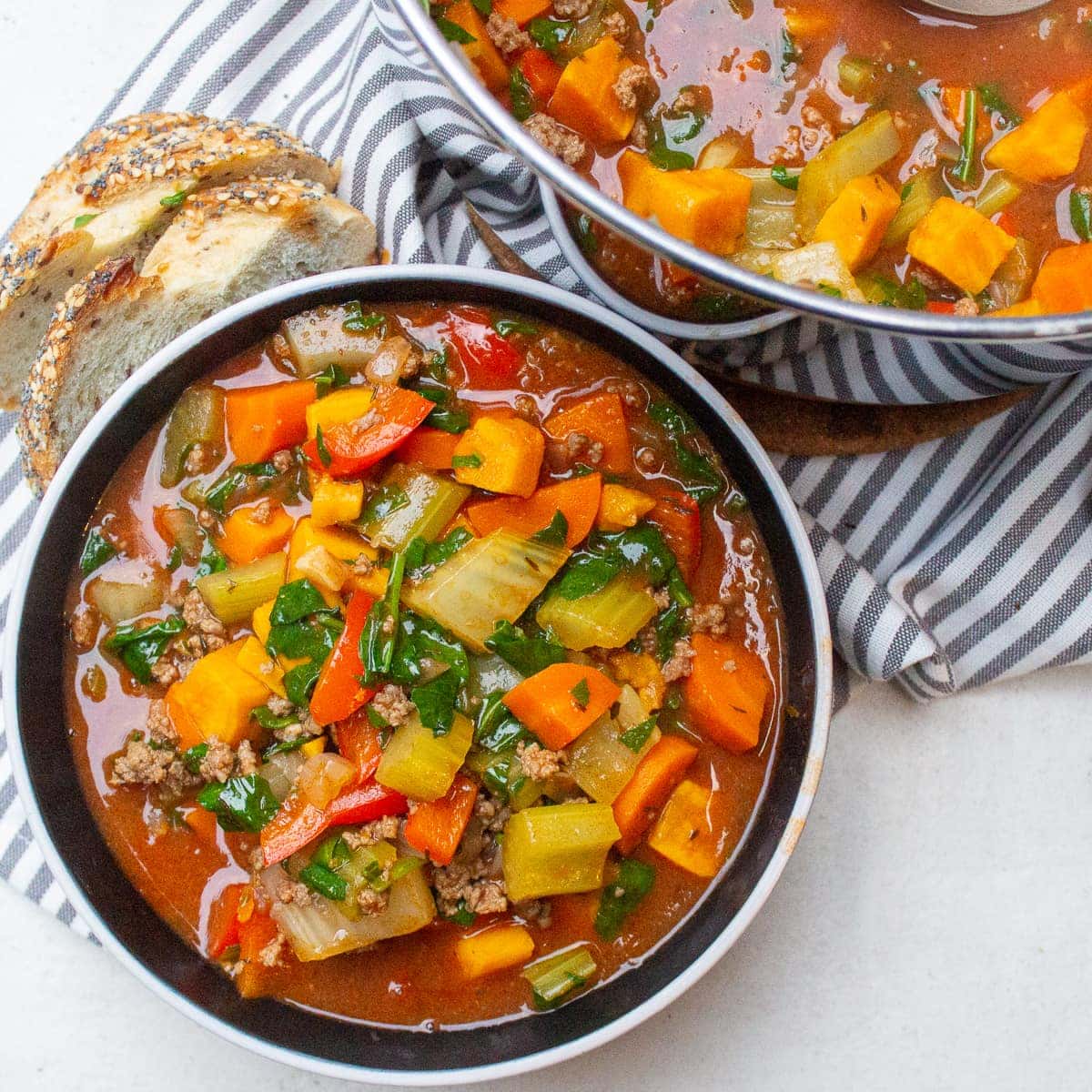 bowl of beef vegetable soup beside pot