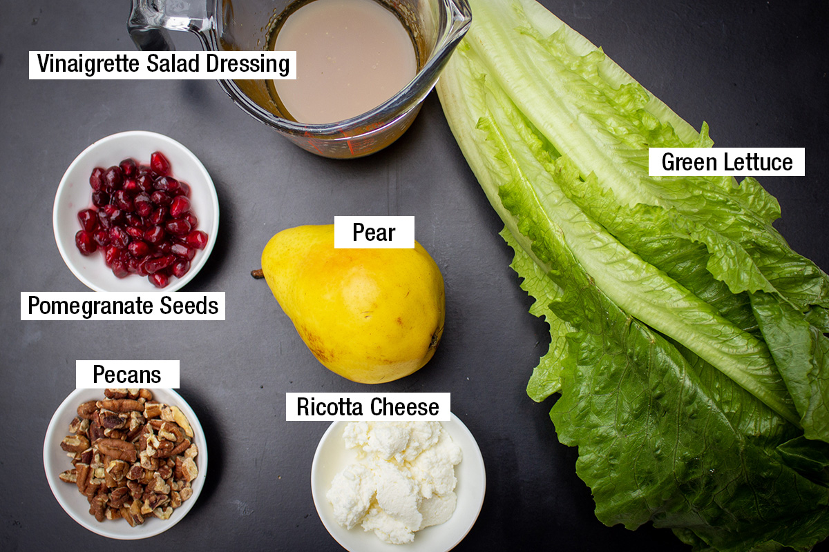 green lettuce, pomegranate seeds, pear, pecans, ricotta cheese, vinaigrette salad dressing.