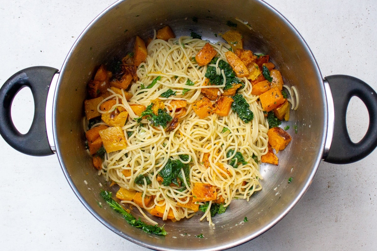 pasta with squash kale and sauce in pot
