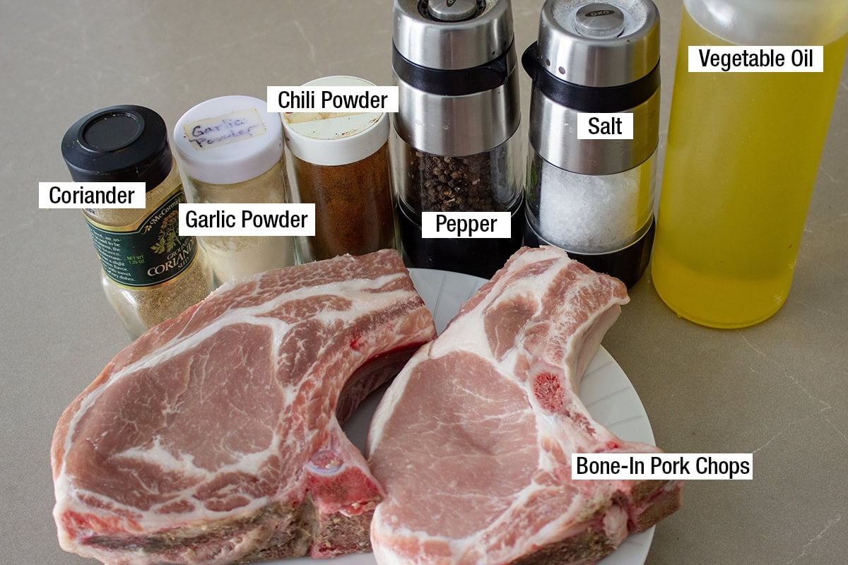 Bone-in pork chops, coriander, garlic and chili powder, salt, pepper, vegetable oil.