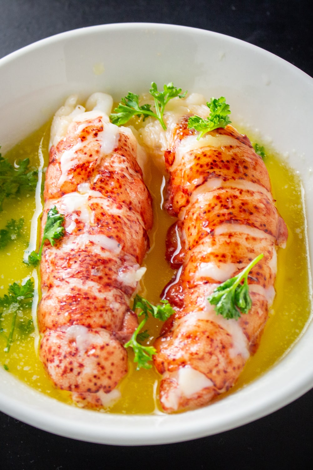 2 lobster tails in butter in dish p