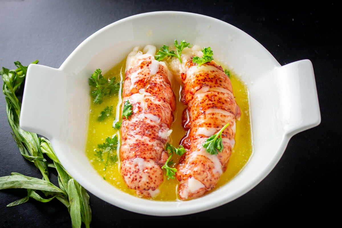 2 lobster tails in butter in dish