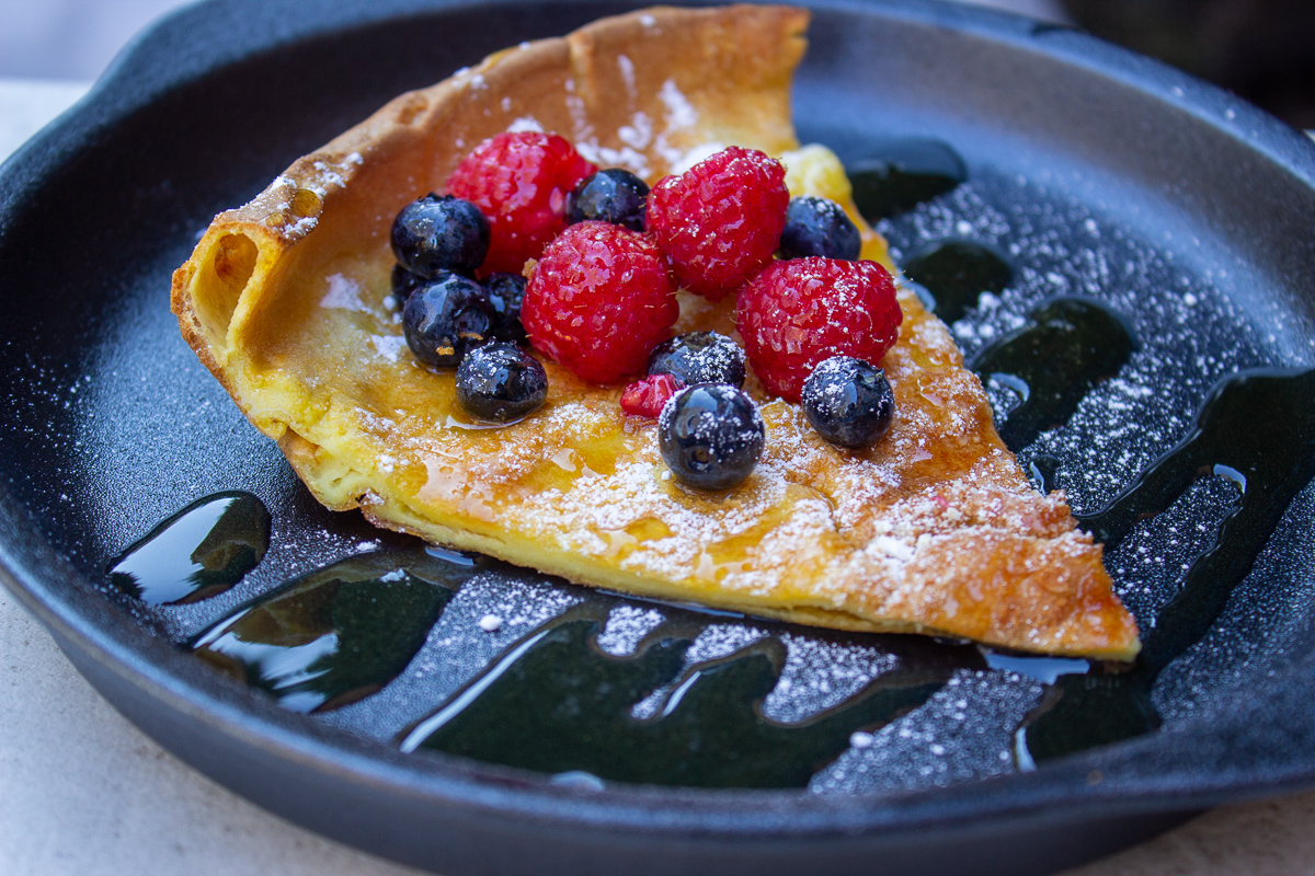 slice of dutch pancake with berries on plate