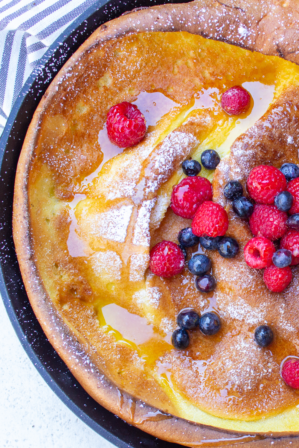 dutch pancaked puffed oven in skillet with berries and syrup on top p