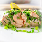 fillet of salmon with roasted with herbs on plate with lemon