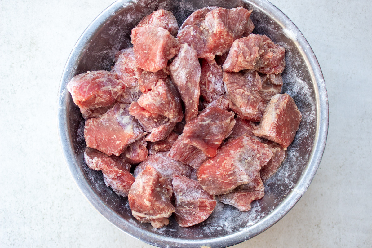 cubes of beef dusted with flour in bowl
