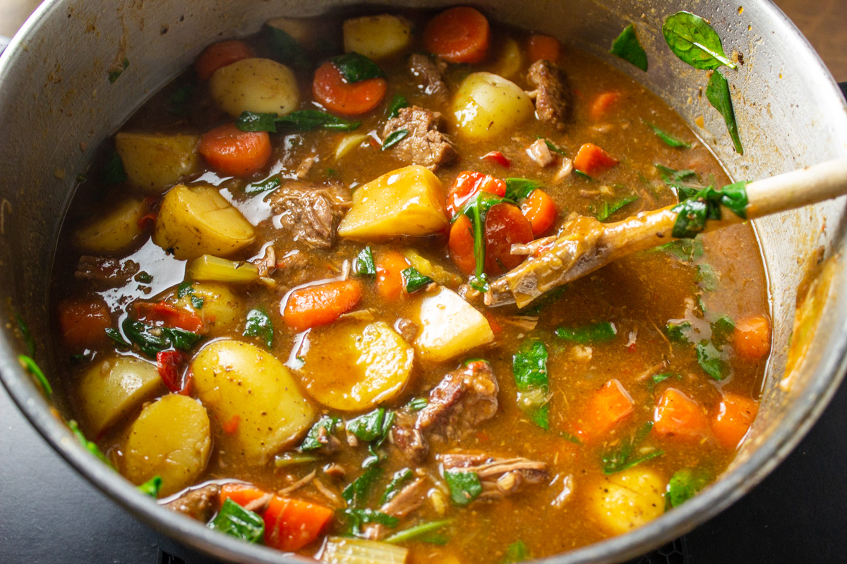 beef stew in pot with wooden spoon