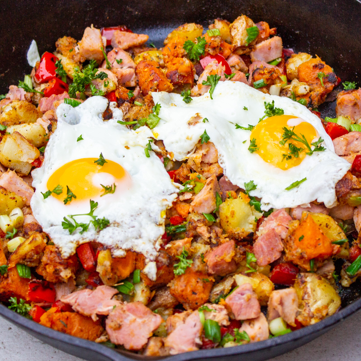 potato breakfast ham hash with eggs in skillet