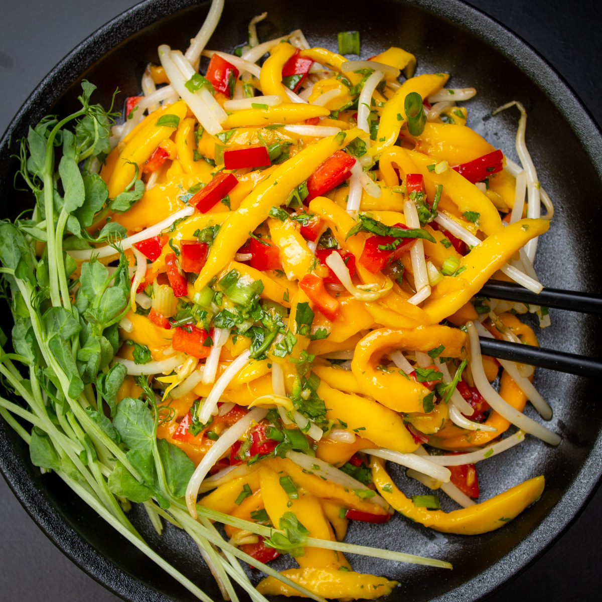 Thai mango salad on black plate