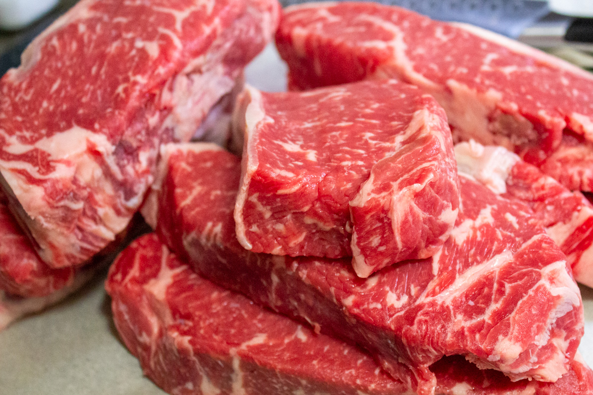 8 new york strip steaks on cutting board