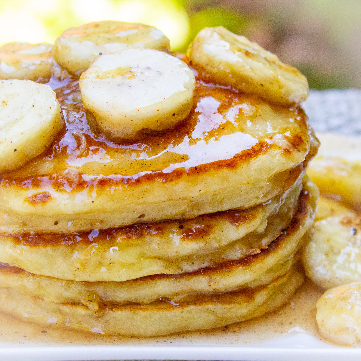 stack of ricotta pancakes with caramelized bananas on plate