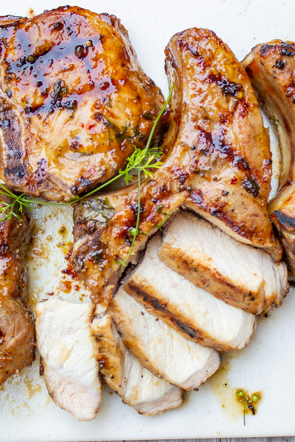 glazed grilled pork chops on board with one sliiced