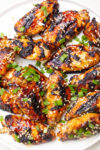 chicken wings on plate with sesame seeds and green onions p