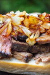 beef chuck roast sliced on bread with caramelized onions p