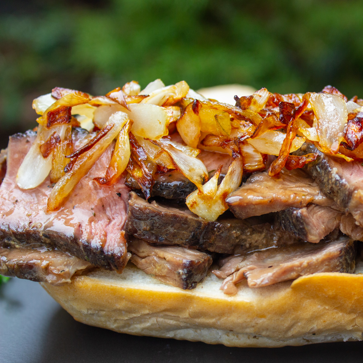 beef chuck roast sliced on bread with caramelized onions