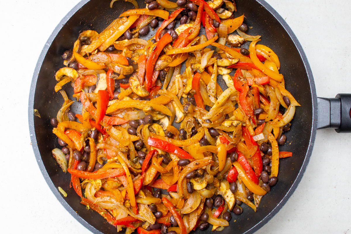 cooked veggies, beans and fajita seasoning in skillet