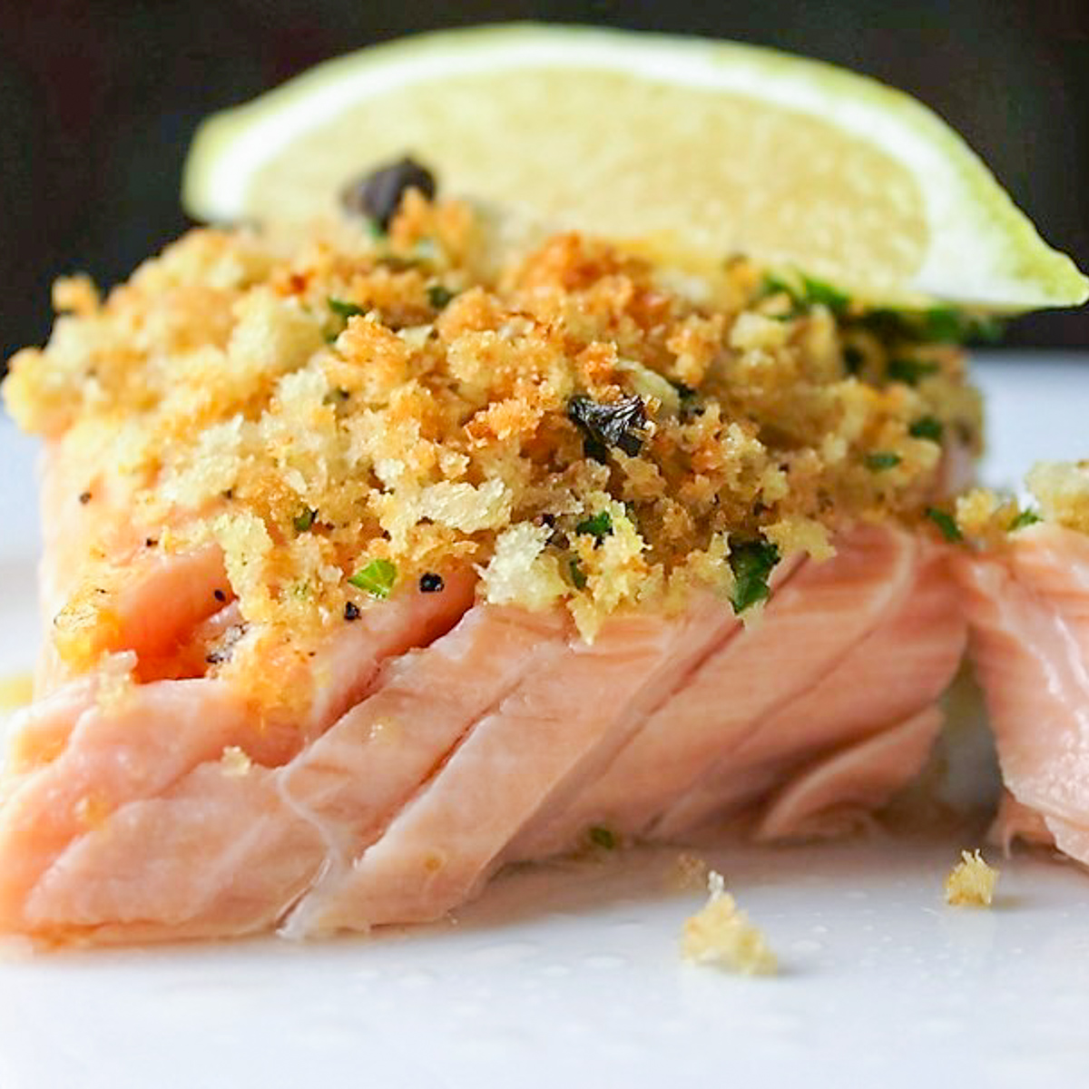 piece of salmon with panko crust on plate and lemon wedge