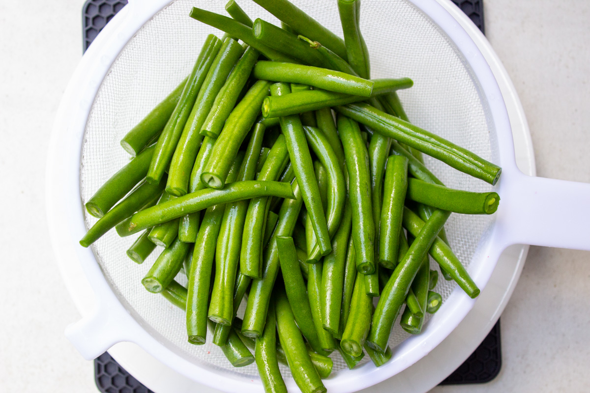 trimmed green beans in white bowl