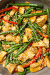 chicken and green bean stir fry in skillet with sesame seeds p